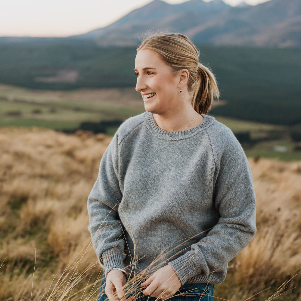 
                      
                        Lady standing on a hill wearing a McIvor Hill lambs' wool Rita sweater in grey.
                      
                    