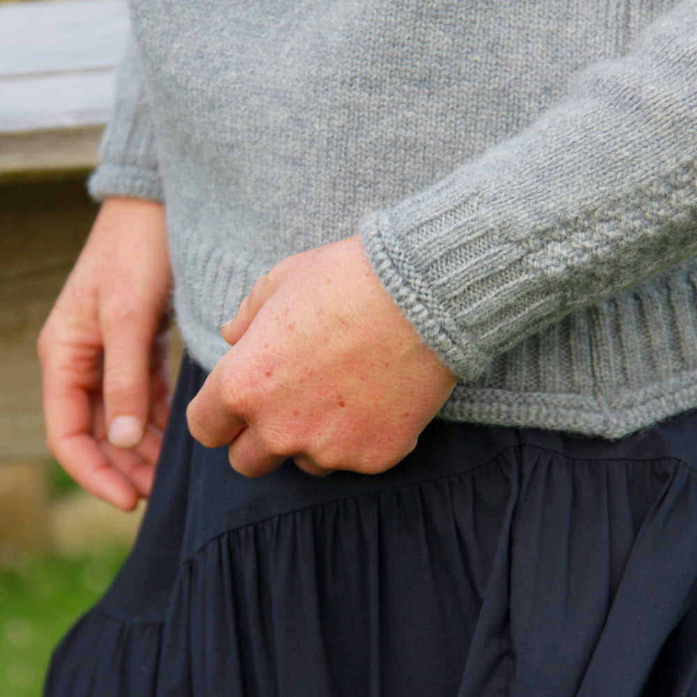 
                      
                        Cuff and hem detail of our McIvor Hill wool Mabel sweater in grey
                      
                    