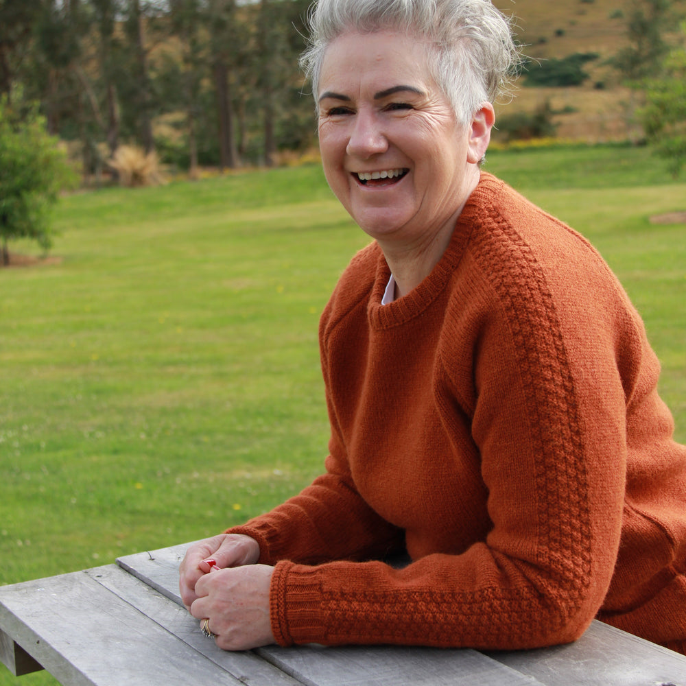 Lady wear McIvor Hill wool Mabel sweater in rust.